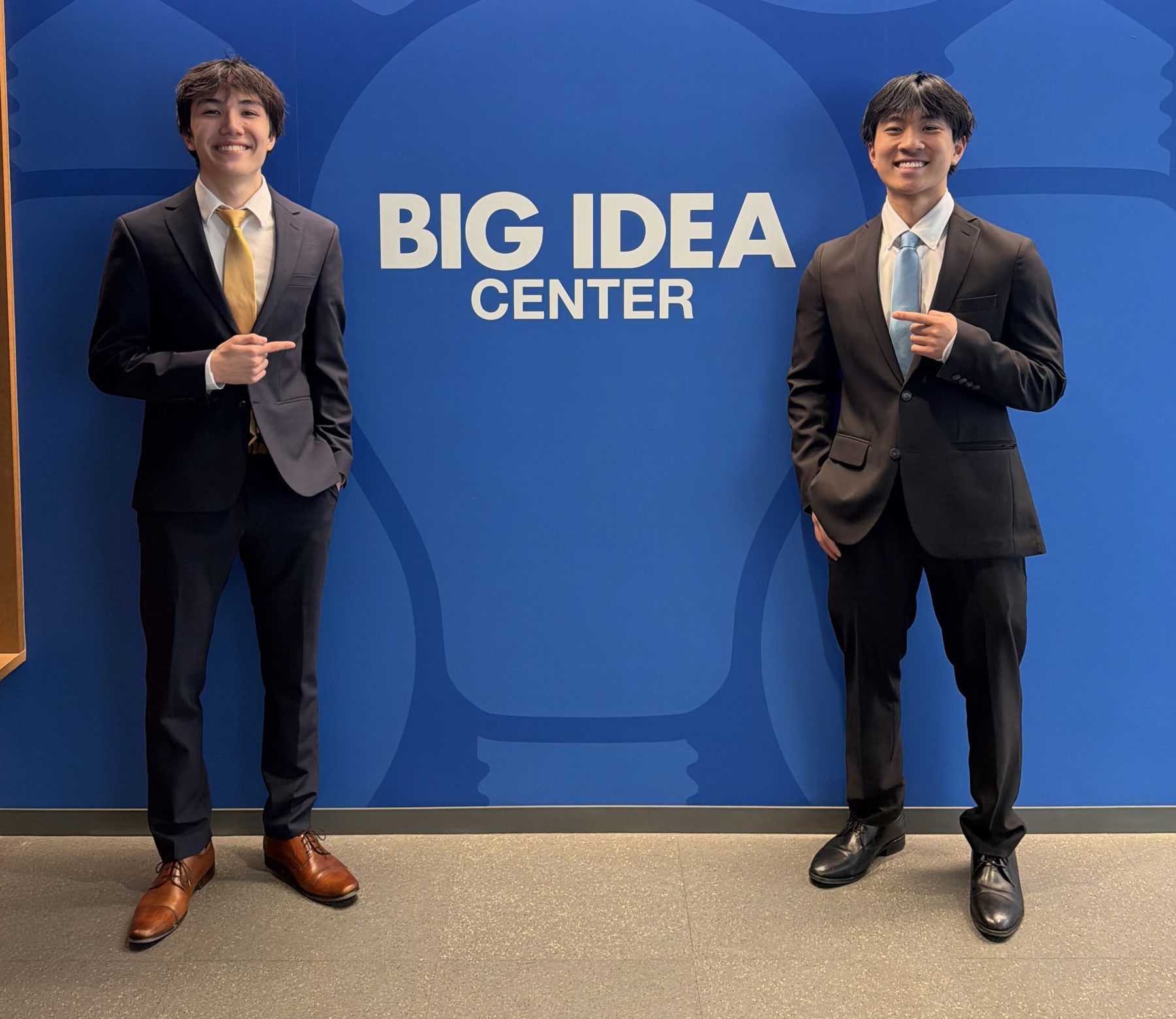 Kai Morales and Daniel Nguyen in suits at the University of Pittsburgh's Big Idea Center.